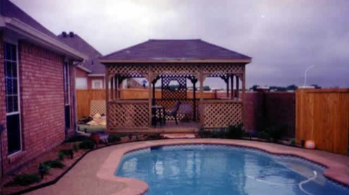 Residential setting displaying a poolside pavilion, house exterior, and patio area