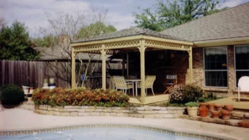 Outdoor seating area covered by a gazebo and overlooking a swimming pool